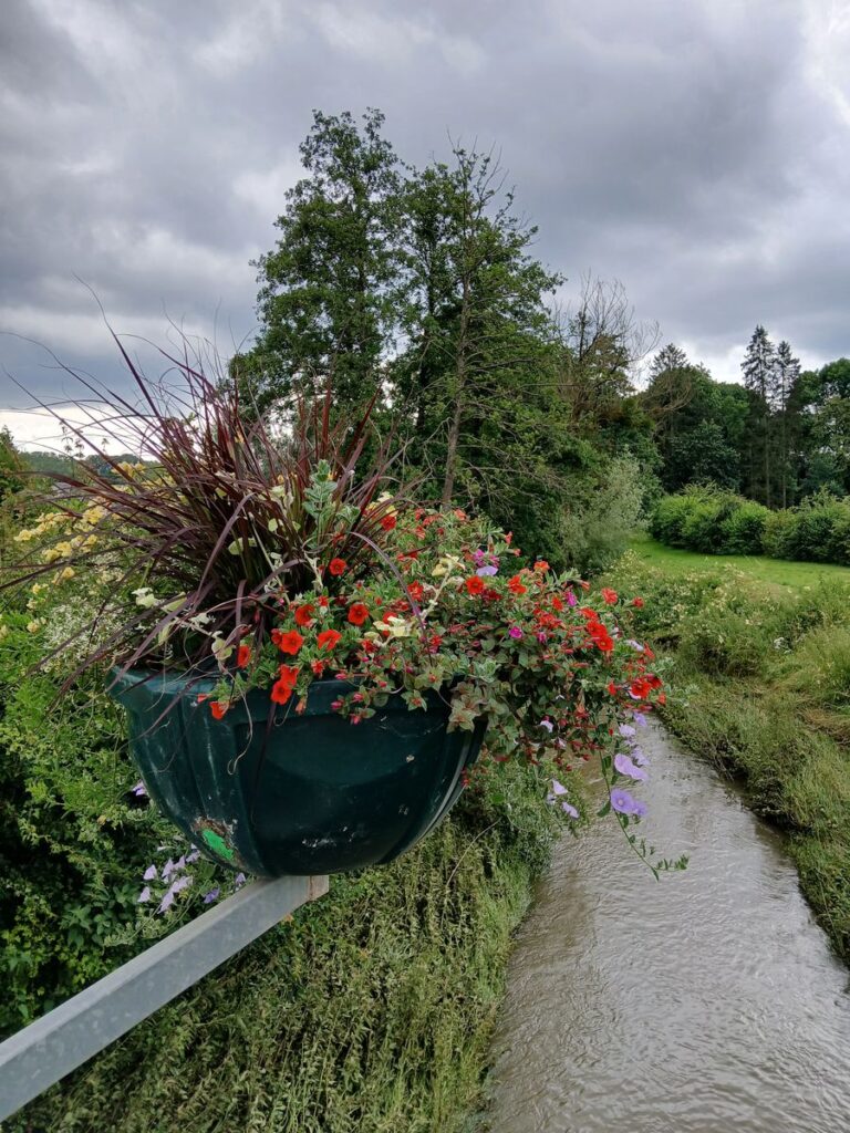 Jolies compositions florales de la commune sur le pont surplombant la Messancy, la rivière éponyme de la commune.